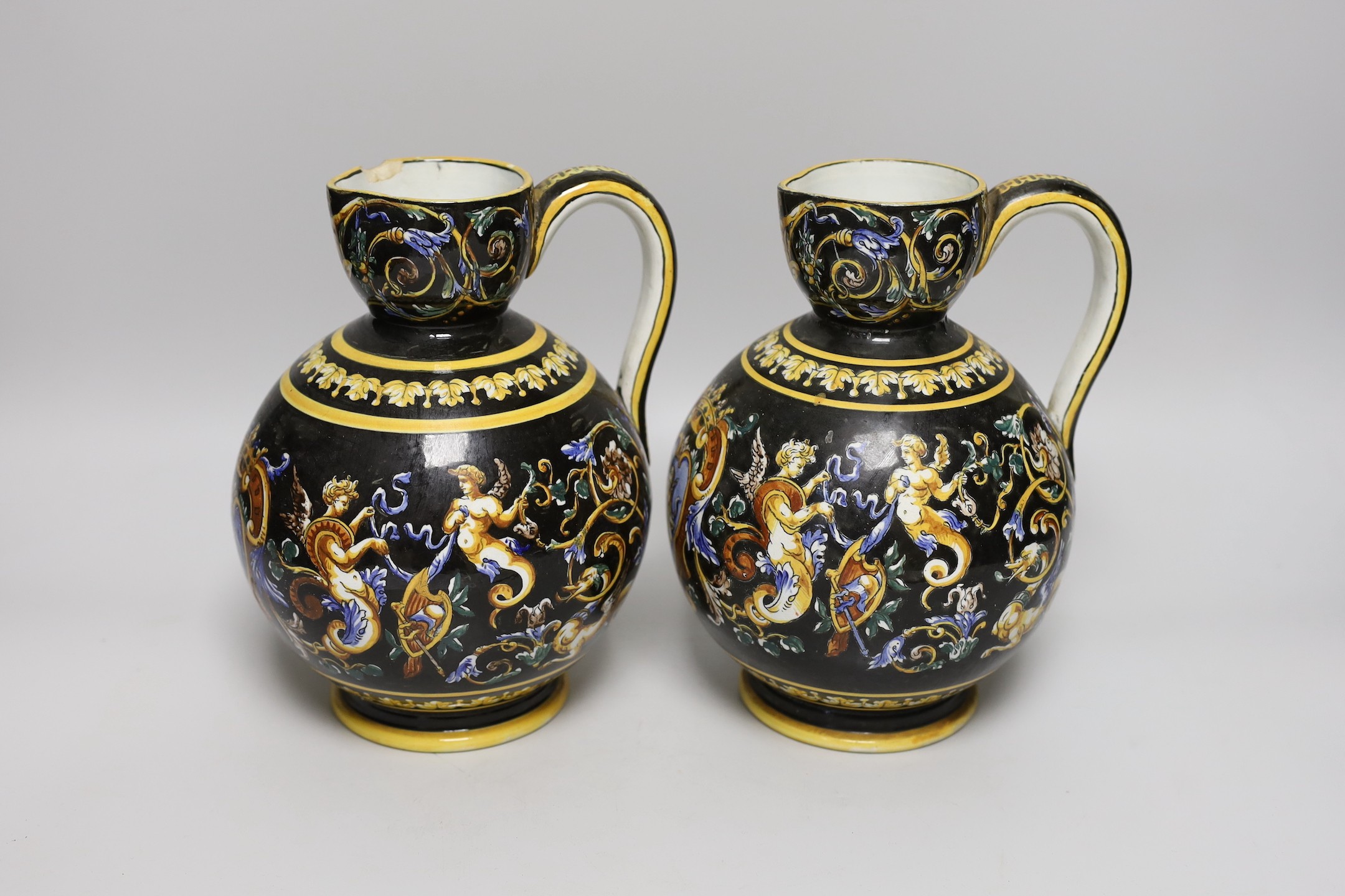 A pair of French maiolica ewers, 22cms high